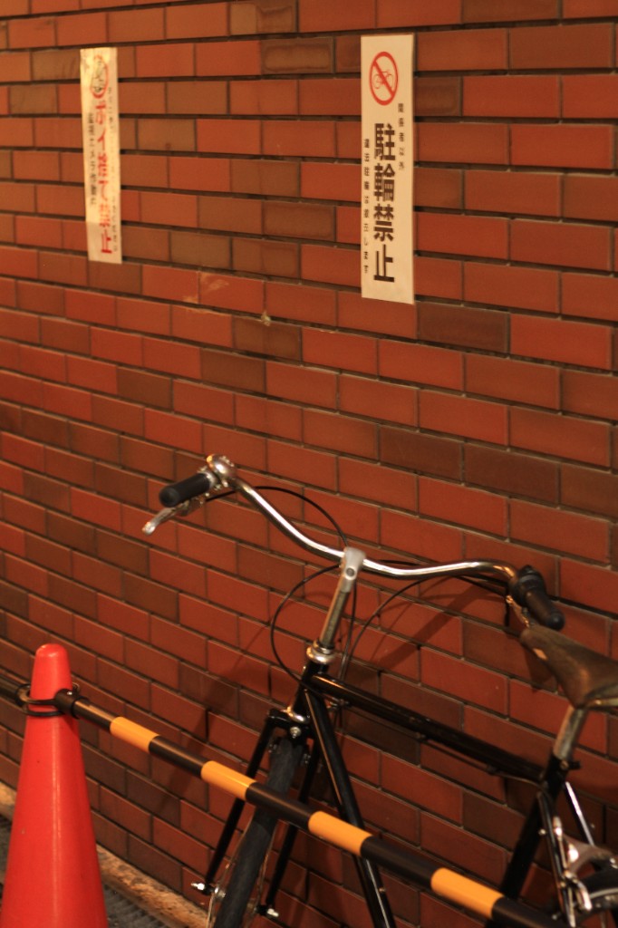 Street — bicycle against brick wall with Japanese signage
